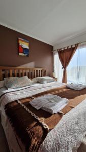 un grande letto con una coperta sopra di Complejo Raíces Patagonicas a Dina Huapi