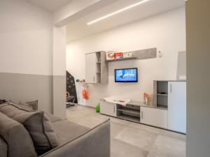 ピエトラ・リーグレにあるBabyaccomodation Family Brightのソファと壁掛けテレビのあるリビングルーム