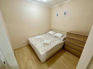 ハイドゥソボスローにあるMárta Apartmanの小さなベッドルーム(ベッド1台、ドレッサー付)