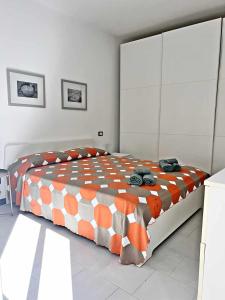 ein Schlafzimmer mit einem Bett mit einer orangen und weißen Bettdecke in der Unterkunft Petite Rivière in centro a Chiavari in Chiavari