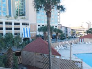 een uitzicht op een resort met een palmboom en een zwembad bij Waipani C15 condo in Myrtle Beach