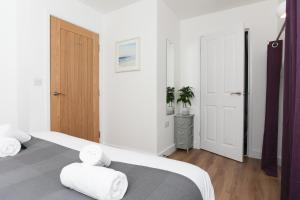 a bedroom with two beds with white sheets and towels at Strawberry Line, Apartment 2 in Wells