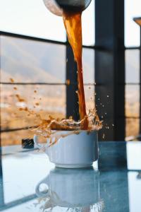 a person pouring food into a pot on a table at Origen75 Loft - Villas - Skypool - Viñedo, Valle de Guadalupe in Valle de Guadalupe