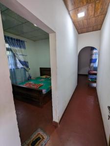 1 dormitorio con 1 cama en una habitación con espejo en DILSHAN HOTEL Diyaluma, en Koslanda