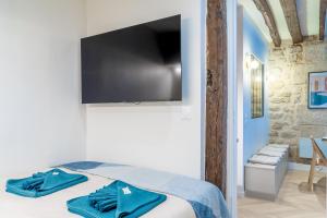 a bedroom with a bed with a flat screen tv on the wall at Lavie Maison AC & Jacuzzi in Paris