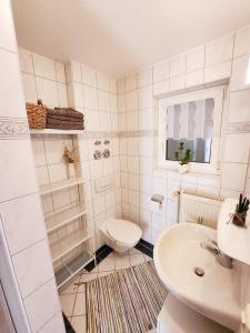 a white bathroom with a toilet and a sink at Ferienwohnung Herzlicht in Titisee-Neustadt