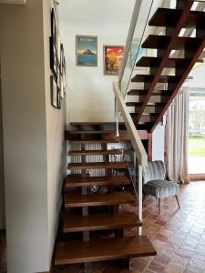 a staircase with wooden treads and a chair in a house at 3 chambres dans une magnifique propriété in Luc-sur-Mer