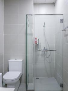 a bathroom with a toilet and a glass shower at Penang Straits Garden Condominium Georgetown in George Town