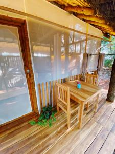 - une table en bois sur la terrasse couverte d'une maison dans l'établissement EcoAraguaia Jungle Lodge, 