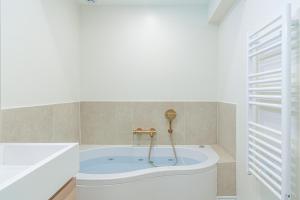 a bathroom with a tub in the corner of a room at Lavie Maison AC & Jacuzzi in Paris