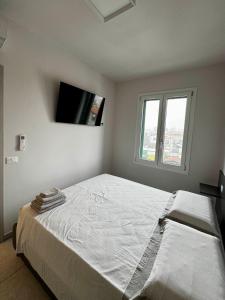 a bedroom with a large bed with a tv on the wall at Suite Nazioni in Lido delle Nazioni