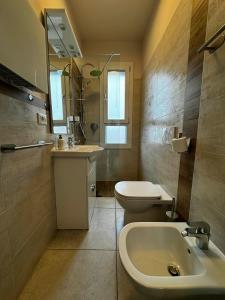 a bathroom with a sink and a toilet and a mirror at Suite Nazioni in Lido delle Nazioni