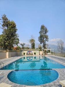 a swimming pool with blue water in a yard at Ranikheth Ecostay in Kalimpong