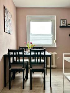 comedor con mesa, sillas y ventana en Ferienwohnung Paulita en Soltau