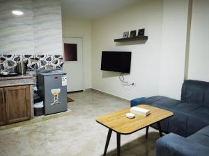 un soggiorno con divano blu e tavolo di Hospitality apartments a Wadi Musa