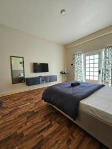 um quarto com uma cama grande e uma televisão em Ranikheth Ecostay em Kalimpong