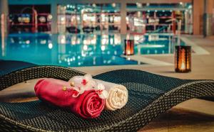 a doll sitting on a chair next to a pool at Wellness & Spa Hotel Kaskady in Sliač