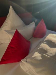 two red pillows sitting on top of a bed at Palace St. George in Mönchengladbach