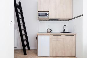 a small kitchen with a sink and a microwave at Starowiślna Studio Kazimierz Cracow by Renters in Krakow
