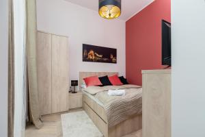 a bedroom with a bed and a flat screen tv at Starowiślna Studio Kazimierz Cracow by Renters in Krakow