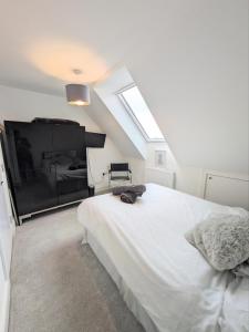 een slaapkamer met een groot wit bed en een raam bij The Penthouse Double Bedroom for Rent Free Parking in Epsom