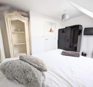 a bedroom with a white bed with two pillows on it at The Penthouse Double Bedroom for Rent Use of kitchen in Epsom