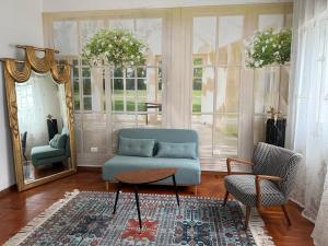 a living room with a blue couch and two chairs at VILLA TARA in Quercianella