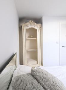 a bedroom with a white cabinet and a bed at The Penthouse Double Bedroom Free Parking in Epsom