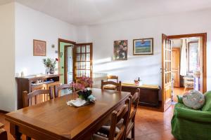 une salle à manger avec une table en bois et un canapé vert dans l'établissement Casa Gigina, à Stazzema