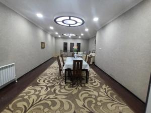 a dining room with a table and chairs on a carpet at Uzbegim Family Guest House in Bukhara