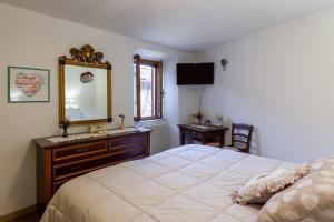 - une chambre avec un lit, une commode et un miroir dans l'établissement Casa Gigina, à Stazzema
