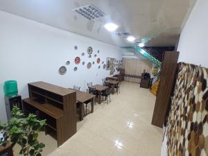 a dining room with tables and chairs and a wall at Uzbegim Family Guest House in Bukhara