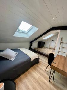 a bedroom with a bed and a desk and a skylight at La Casa du Lac in Le Bourget-du-Lac