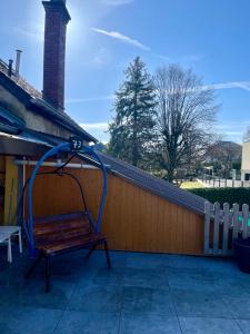 un banco en un porche con una manguera de agua en La Casa du Lac en Le Bourget-du-Lac