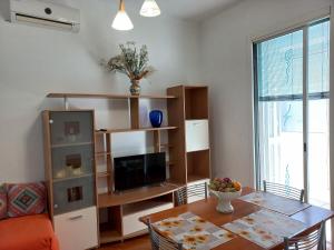 a living room with a table and a television at OASI CL in Bari