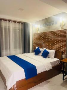 a bedroom with a large bed with blue pillows at Roya Khmer House in Siem Reap