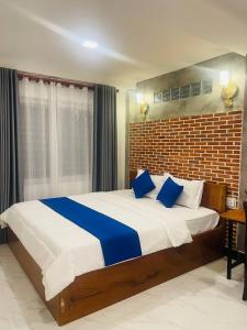 um quarto com uma cama grande e almofadas azuis em Roya Khmer House em Siem Reap