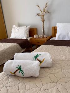Habitación de hotel con 2 camas y toallas. en Dionisos Roses, en Paralia Dionisiou