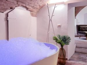 La salle de bains est pourvue d'une baignoire bleue. dans l'établissement Medieval flat with whirlpool bath, à Pérouse