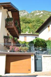 ein Gebäude mit einer hölzernen Garagentür und Blumen in der Unterkunft ALLA CAMPANELLA in Riva del Garda