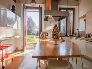 uma cozinha com uma mesa de madeira e uma grande janela em Cascina Torriggio Estates em Rozzano