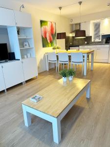 a living room with a table and a kitchen at Appartement Kompas in Hollum