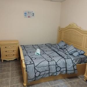 1 cama con edredón azul y almohadas en العين الهيلي مصباح ب1, en Al Ain
