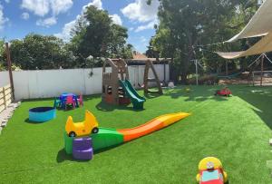 een speeltuin met een glijbaan in een tuin met gras bij 4BlessingsCuracao 1B in Willemstad