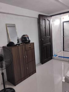 Zimmer mit einem Spiegel und einer Tür in der Unterkunft Vin's Place Rentals - Studio Unit in Tagum