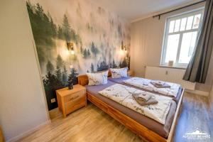 - une chambre avec 2 lits et un tableau mural dans l'établissement Auszeit im Harz Haus 1 Wohnung Feuerstein, à Schierke