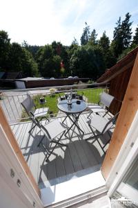 um pátio com uma mesa e cadeiras num deque em Auszeit im Harz Haus 1 Wohnung Feuerstein em Schierke