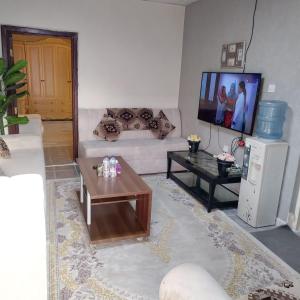 uma sala de estar com um sofá e uma televisão em العين الهيلي مصباح ب1 em Al Ain