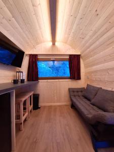 a living room with a couch in a tiny house at Presanella Mountain Lodge in Temù