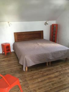 a bedroom with a bed and a red chair at Le Récif, maison indépendante Corniche de la mer in Concarneau +33 photos